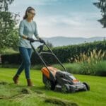 Femme tondant la pelouse avec scarificateur électrique, entourée d'arbres, fleurs et montagnes verdoyantes.